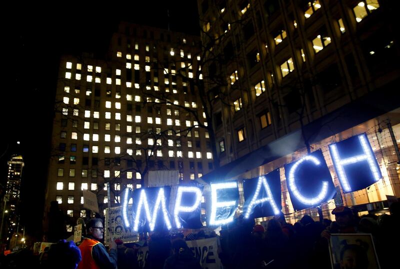 Protesters hold a lit-up "impeach" sign in Seattle. Reuters