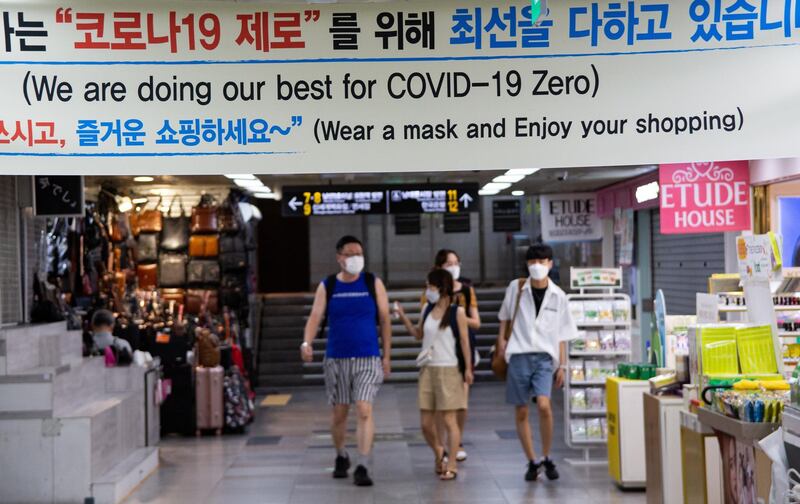 People wearing masks walk around Namdaemun market in Seoul, South Korea.  EPA
