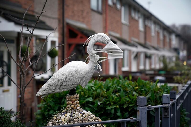 An ornamental garden bird wears a face mask outside a home in Manchester, UK.  Getty Images