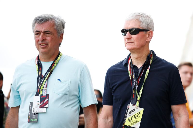 Apple CEO Tim Cook, right, and Eduardo Humberto Cue walk in the Paddock prior to the F1 Grand Prix of USA. AFP