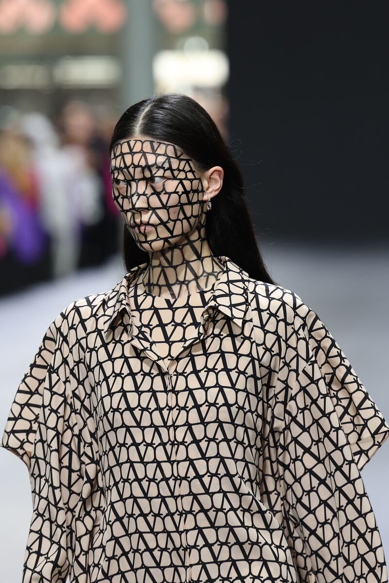 Opening the show, a model has the Valentino logo painted on her. Getty 