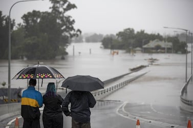 People look out at the Hawkesbury River Bridge submerged by floodwaters in Windsor, New South Wales, Australia, on Monday, March 22, 2021. Western Sydney and the NSW Mid-North coast are bearing the brunt of the relentless downpour that has caused the Warragamba Dam, Sydney’s primary source of water, to overflow for the first time in five years, and caused severe damage to property and roads. Photographer: Brent Lewin/Bloomberg
