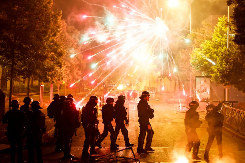 French police stand in position as fireworks go off during clashes in Nanterre, Paris. Reuters