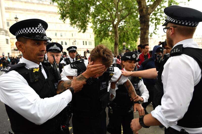 An injured police officer, who appeared to have been struck in the head by a thrown object, is assisted by his colleagues during a Black Lives Matter protest at Trafalgar Square in London. Getty Images