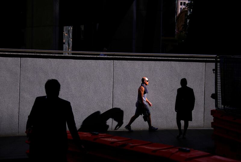 A man is lit by the sun as he walks with other pedestrians along a street on a spring day in the central business district (CBD) of Sydney, Australia, October 9, 2017. REUTERS/David Gray