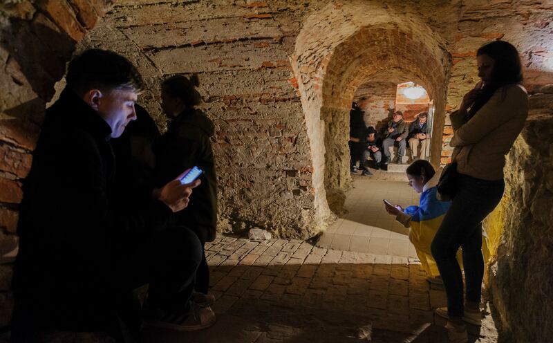 Local people share a basement of a historical building which is being used as a bomb shelter during an air raid warning in Lviv. EPA