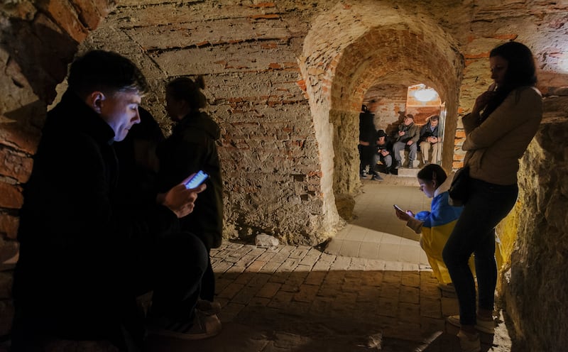 Local people share a basement of a historical building which is being used as a bomb shelter during an air raid warning in Lviv. EPA