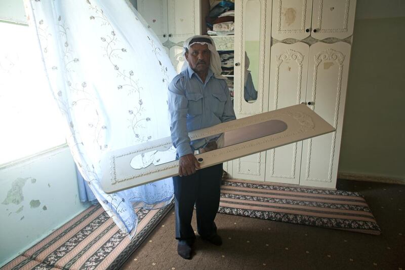 Palestinian Mohammed Mahmoud Ruziqat, 64, shows the broken mirror in one of the bedrooms in his home in the village of Tufa on the outskirts of Hebron, on June 19, 2014. Earlier this week, the Israeli army arrived at his son’s home, demanding for a place to sleep in. Heidi Levine / The National 