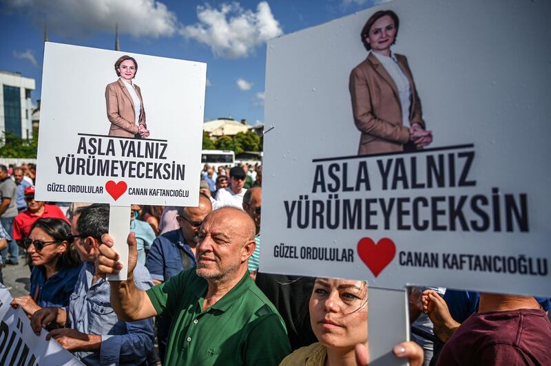 Protesters hold up placards reading 'You will never walk alone' as they demonstrate in front of Caglayan court house in Istanbul in support of Republican People's Party chief Canan Kaftancioglu, who faces up to 17 years in prison for allegedly 'insulting the Turkish President'. AFP