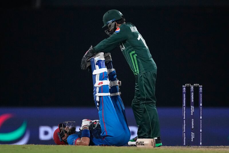 Pakistan's Mohammad Rizwan, right, helps Afghanistan's Ibrahim Zardan to ease a leg cramp. AP P