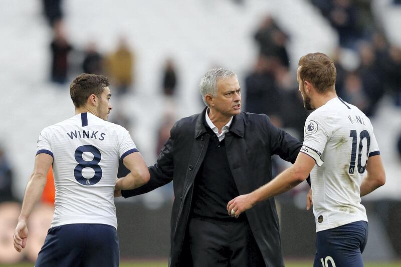 Tottenham Hotspur's Portuguese head coach Jose Mourinho interacts with Tottenham Hotspur's English striker Harry Kane (R) and Tottenham Hotspur's English midfielder Harry Winks (L) at the final whistle during the English Premier League football match between West Ham United and Tottenham Hotspur at The London Stadium, in east London on November 23, 2019. - Tottenham Hotspur beat West Ham United 3-2. (Photo by Adrian DENNIS / AFP) / RESTRICTED TO EDITORIAL USE. No use with unauthorized audio, video, data, fixture lists, club/league logos or 'live' services. Online in-match use limited to 120 images. An additional 40 images may be used in extra time. No video emulation. Social media in-match use limited to 120 images. An additional 40 images may be used in extra time. No use in betting publications, games or single club/league/player publications. / 