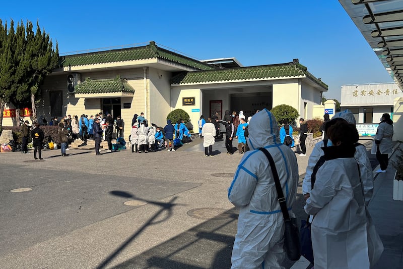 People stand outside a funeral home in Shanghai, as cases of Covid-19 surge in China. Reuters