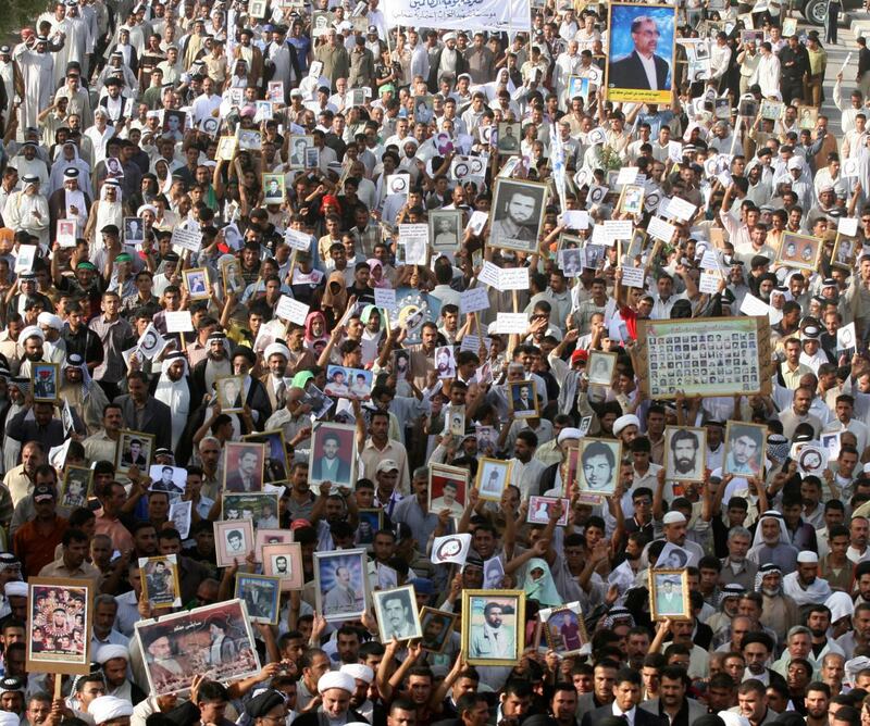 Demonstrators hold pictures of missing and killed relatives during a protest in Najaf in 2008. Reuters