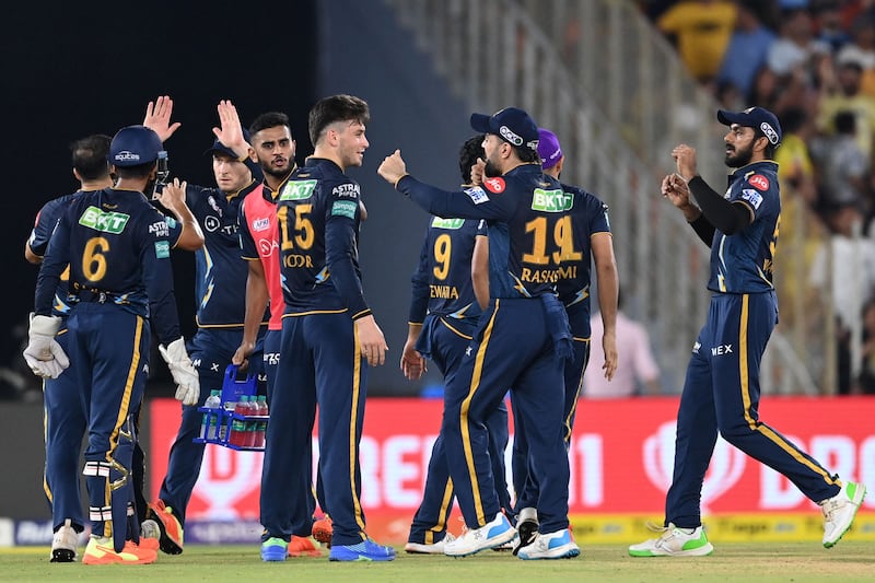 Gujarat Titans' Noor Ahmad celebrates with teammates after taking the wicket of Chennai Super Kings' Devon Conway. AFP
