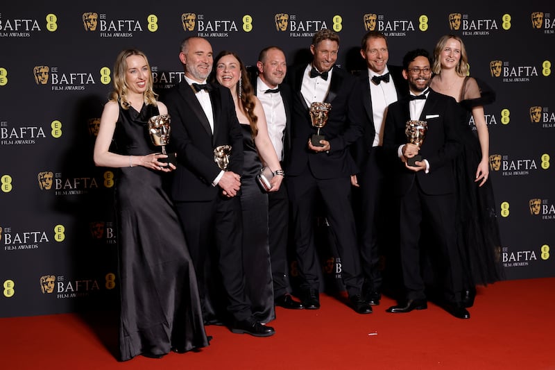 Jane Paton, left, Simon Hughes, left, Tim Barter, fourth right, and Dean Koonjul, second right, pose with the Best Special Visual Effects award for Poor Things. Getty Images