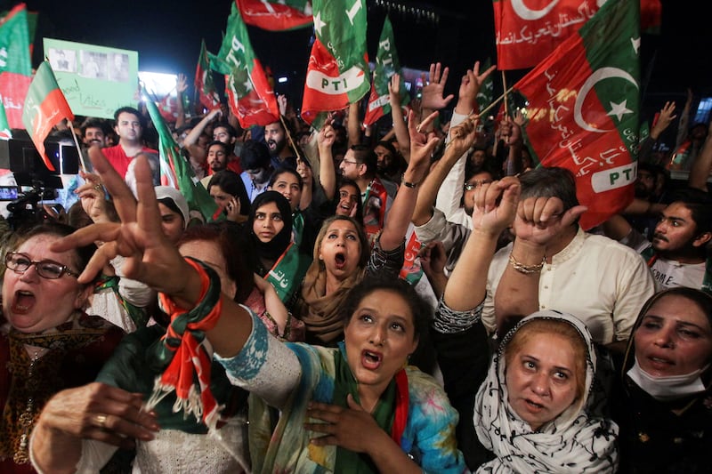 Fans throw their weight behind Mr Khan, during a demonstration in Lahore. Reuters