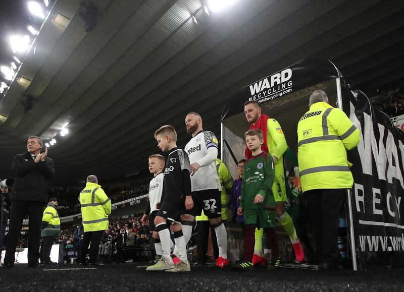 Derby captain Wayne Rooney leads his team out before the match. Reuters