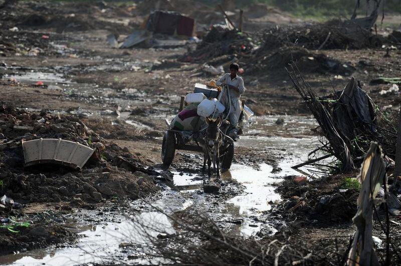 An Afghan refugee riding on a donkey-cart loaded with his belongings that he salvaged from the ruins of his mud house destroyed by the authorities in the slums of Islamabad. Aamir Qureshi / AFP