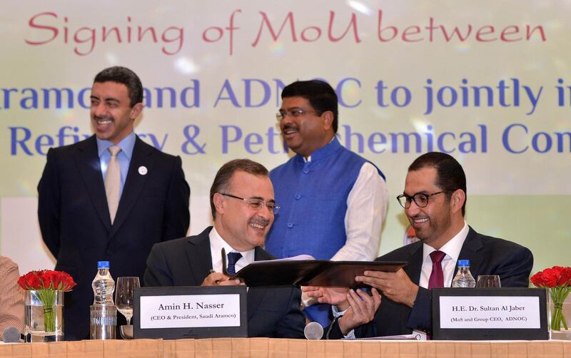Saudi Aramco CEO Amin Nasser (2nd L) and Abu Dhabi National Oil Company (ADNOC) chief executive and United Arab Emirates (UAE) Minister of State Sultan Ahmed Al Jaber (R) sign a memorandum of understanding as Indian Oil Minister Dharmendra Pradhan (2nd R) and UAE Foreign Minister Sheikh Abdullah bin Zayed Al Nahyan (L) look on during an event in New Delhi on June 25, 2018.  / AFP / -
