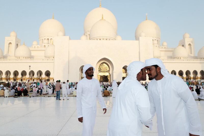 Emirati men greet each other after Eid prayers at Sheikh Zayed Grand Mosque in Abu Dhabi. Christopher Pike / The National