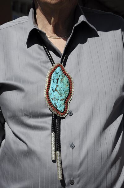 SANTA FE, NM - AUGUST 23, 2014: A man visiting the annual Santa Fe Indian Market wears an elaborate Native American bolo tie made from turquoise and coral. The annual Indian Market features Native American artists from tribes and pueblos throughout the United States. (Photo by Robert Alexander/Getty Images)