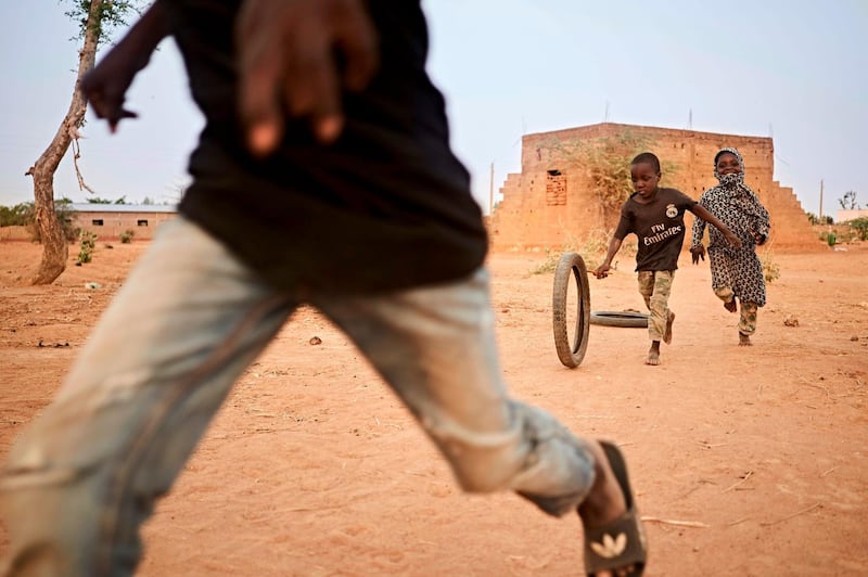 Displaced children play with old tires in a courtyard in Sevare in central Mali, on February 26, 2020. AFP