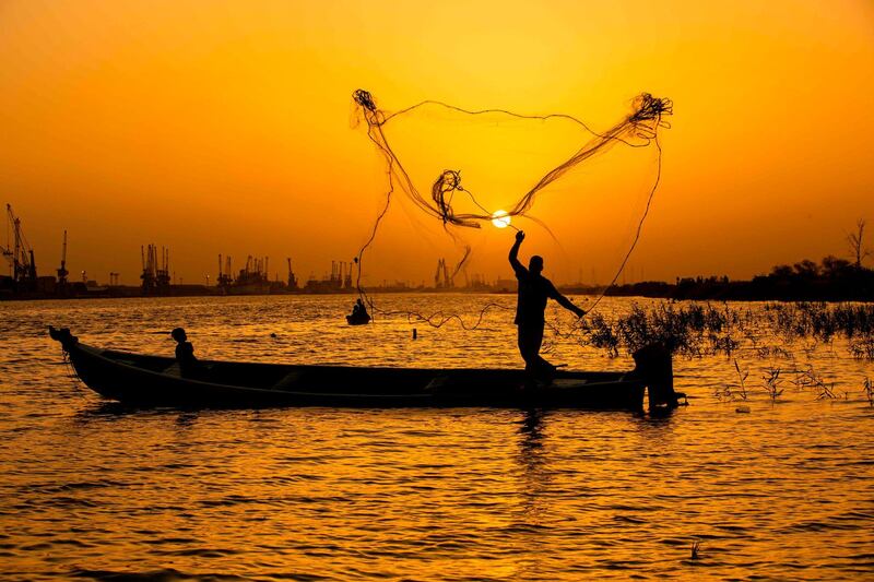 A fisherman casts his net at sunset in the Shatt Al-Arab river, in the southern Iraqi city of Basra. AFP