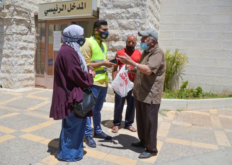 At a medical centre in Amman, volunteer Bahaaldin Atayeh talks to people to persuade them to be immunised against Covid-19. Photo: Reuters