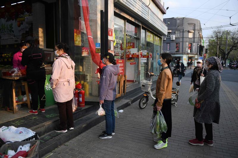 People queue up outside a fruit shop in Beijing. AFP