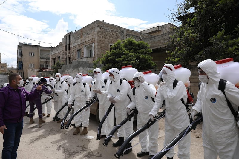 Volunteers from 'Violet Organisation', a local non-government organisation during a disinfection operation in Idlib, Syria.  EPA