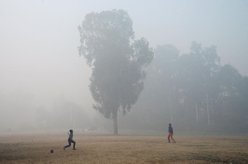Indian children play a game in a field amid dense fog and air pollution in Jalandhar.  Shammi Mehra / AFP Photo