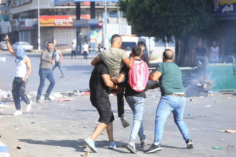 A wounded man is carried during the clashes with Israeli troops.  EPA
