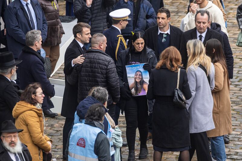 President Macron (centre left) speaks with relatives of the victims. EPA