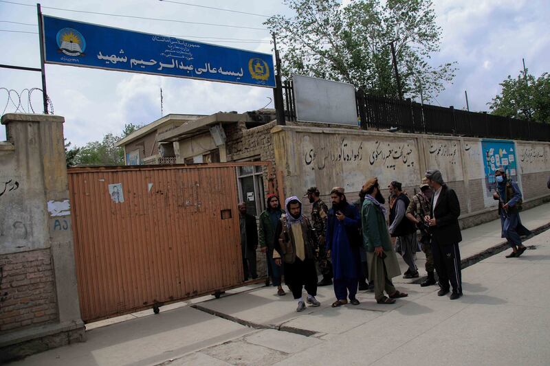 Taliban fighters gather outside the school. In May 2021, at least 85 people – mostly children – were killed in a bombing at another school in the area. EPA