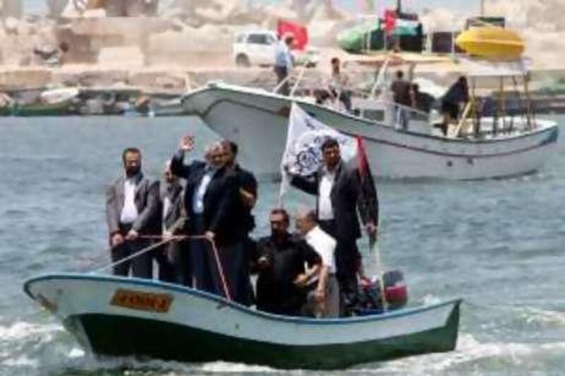 Senior Hamas leader Ismail Haniya (C) waves as he rides a boat off the coast of Gaza City on May 29, 2010 in preparation for the arrival of the "Freedom Flotilla". Organisers of the aid flotilla bound for the Gaza Strip in defiance of an Israeli embargo say it is determined to set sail from international waters off Cyprus, despite delays and threats to intercept the ships. AFP PHOTO/MAHMUD HAMS *** Local Caption ***  636389-01-08.jpg