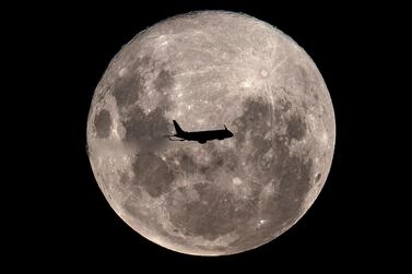 A plane passes by a 'super moon' in February of last year. Courtesy: AFP    