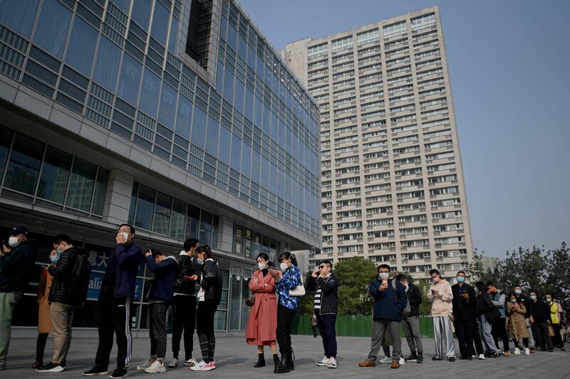 People queue for Covid-19 tests in Beijing on October 25, 2021, as China expands testing to contain an outbreak of the disease in the north. Photo: AFP
