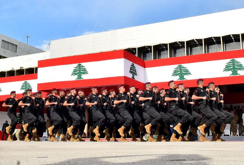 Army soldiers march before the president, prime minister, and parliament speaker during a military parade. AFP