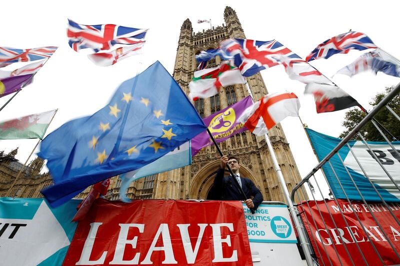 FILE PHOTO: An anti-Brexit protester waves an EU flag outside the Houses of Parliament in London, Britain, October 25, 2019. REUTERS/Henry Nicholls/File Photo