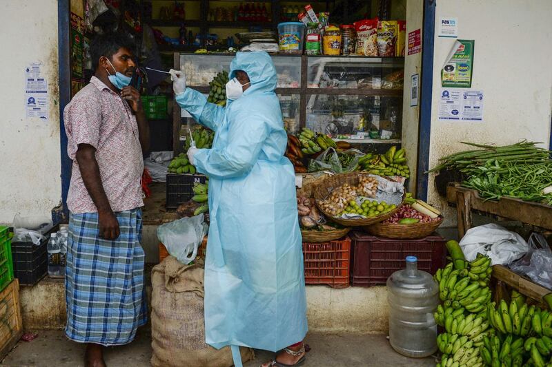 A health worker takes a swab sample from a shopkeeper in Chennai. AFP