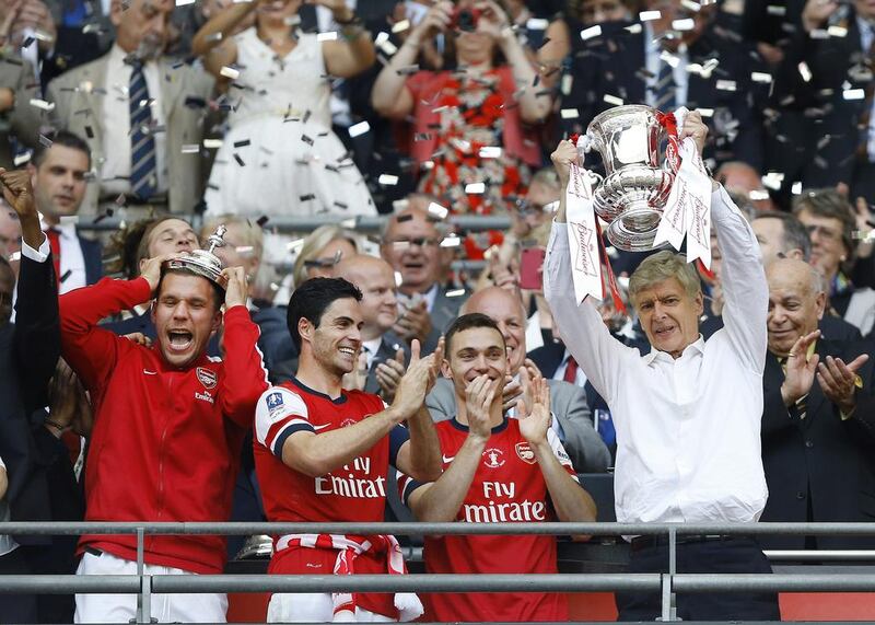 Arsene Wenger, right, led Arsenal to a trophy after nine years. Kirsty Wigglesworth / AP Photo