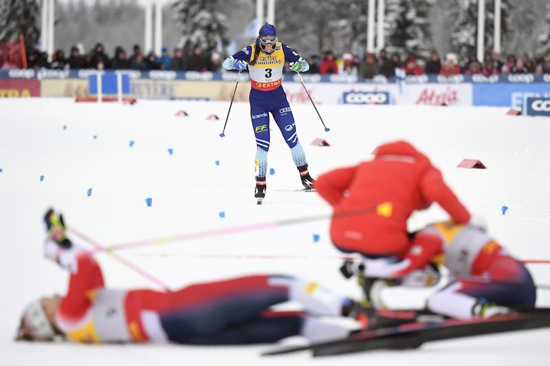 Finland's Krista Parmakoski skis to the finish as Norwegian triple-winners celebrate during the women's cross country freestyle 10 km pursuit at the World Cup in Kuusamo, Finland, on Sunday, December 1. AFP