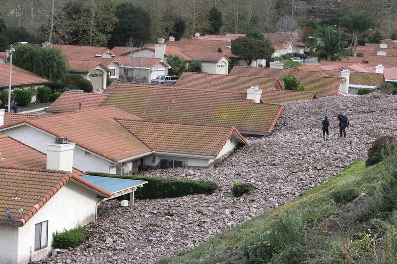 A TV news crew files a report behind damaged homes after a mud slide overtook at least 18 homes during heavy rains in Camarillo Springs, California. Jonathan Alcorn / Reuters