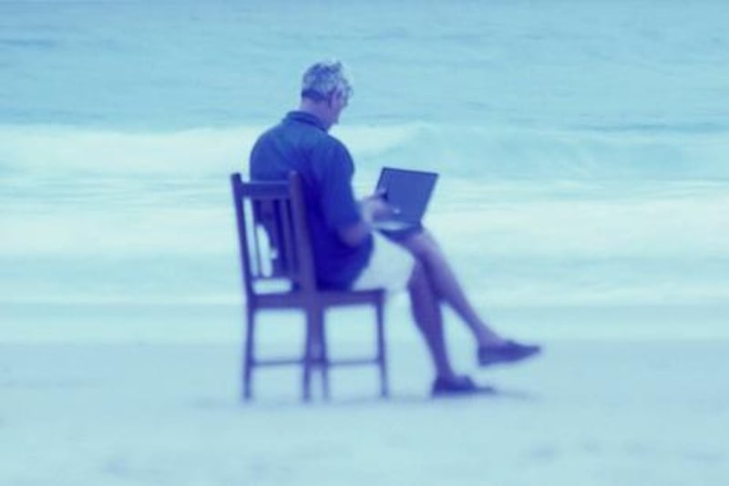 Man Telecommuting on Beach