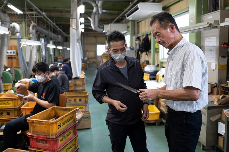 Katsumi Sumikama, right, head of Sumikama Cutlery, checking the quality of a knife at his factory in Seki