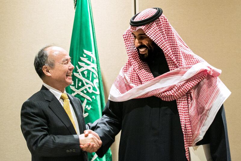 Masayoshi Son, chairman and chief executive officer of SoftBank Group Corp., left, shakes hands with Mohammed bin Salman, Saudi Arabia's crown prince, after signing an agreement in New York, U.S., on Tuesday, March 27, 2018. Saudi Arabia has signed a memorandum of understanding with SoftBank for a $200 billion solar power project in the kingdom, calling it the single largest of its kind in the world. Photographer: Jeenah Moon/Bloomberg