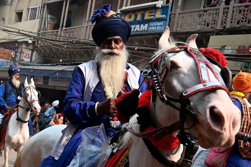 A Nihang, Sikh man who belongs to the armed Sikh order, rides his horse as he participates in "Nagar Kirtan" (religious procession) on the eve of the 550th birth anniversary of Sikhism founder Guru Nanak Dev in New Delhi.   AFP