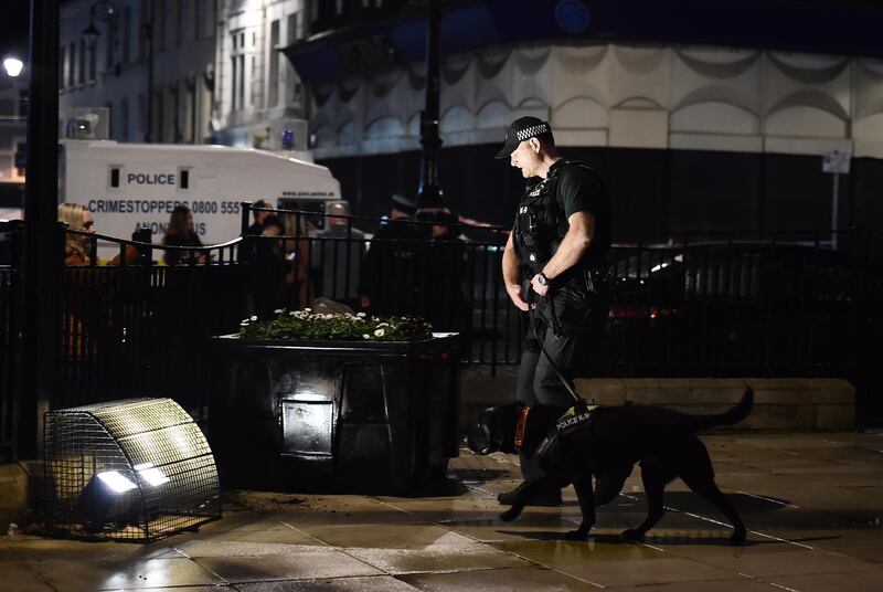 LONDONDERRY, NORTHERN IRELAND - JANUARY 19: A police officer and his sniffer dog inspect the scene near the remains of the car that was earlier hijacked and packed with explosives before being detonated outside Derry court house on January 19, 2019 in Londonderry, Northern Ireland. Dissident republicans are suspected to be behind the attack. (Photo by Charles McQuillan/Getty Images)