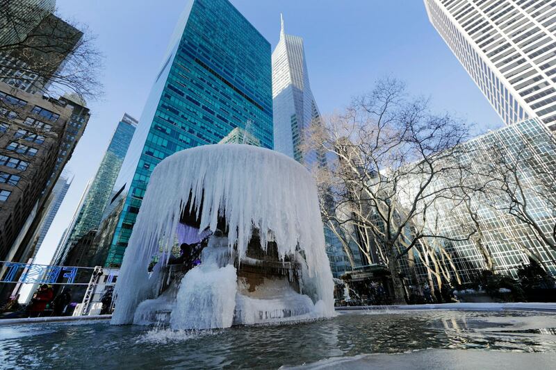 Pedestrians pass a frozen water fountain at Bryant Park in New York. AP Photo