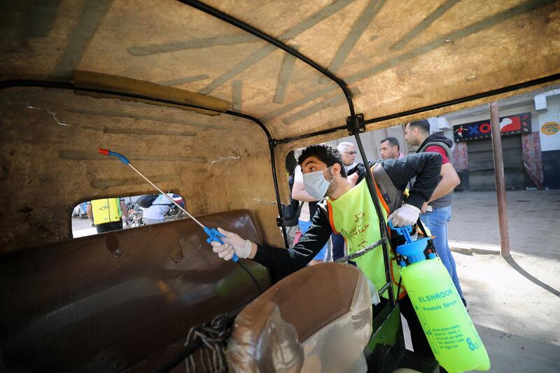 epa08341415 A member of a medical team sprays disinfectant as a precaution against the coronavirus outbreak at a tuk-tuk three wheel motorcycle in Shobra district in Cairo, Egypt, 03 April 2020.  Egyptian authorities have imposed a two-week-long curfew, starting on 25 March, during which all public transportation in the city is suspended due to the ongoing pandemic of the Covid-19 disease caused by the SARS-CoV-2 coronavirus.  EPA/KHALED ELFIQI